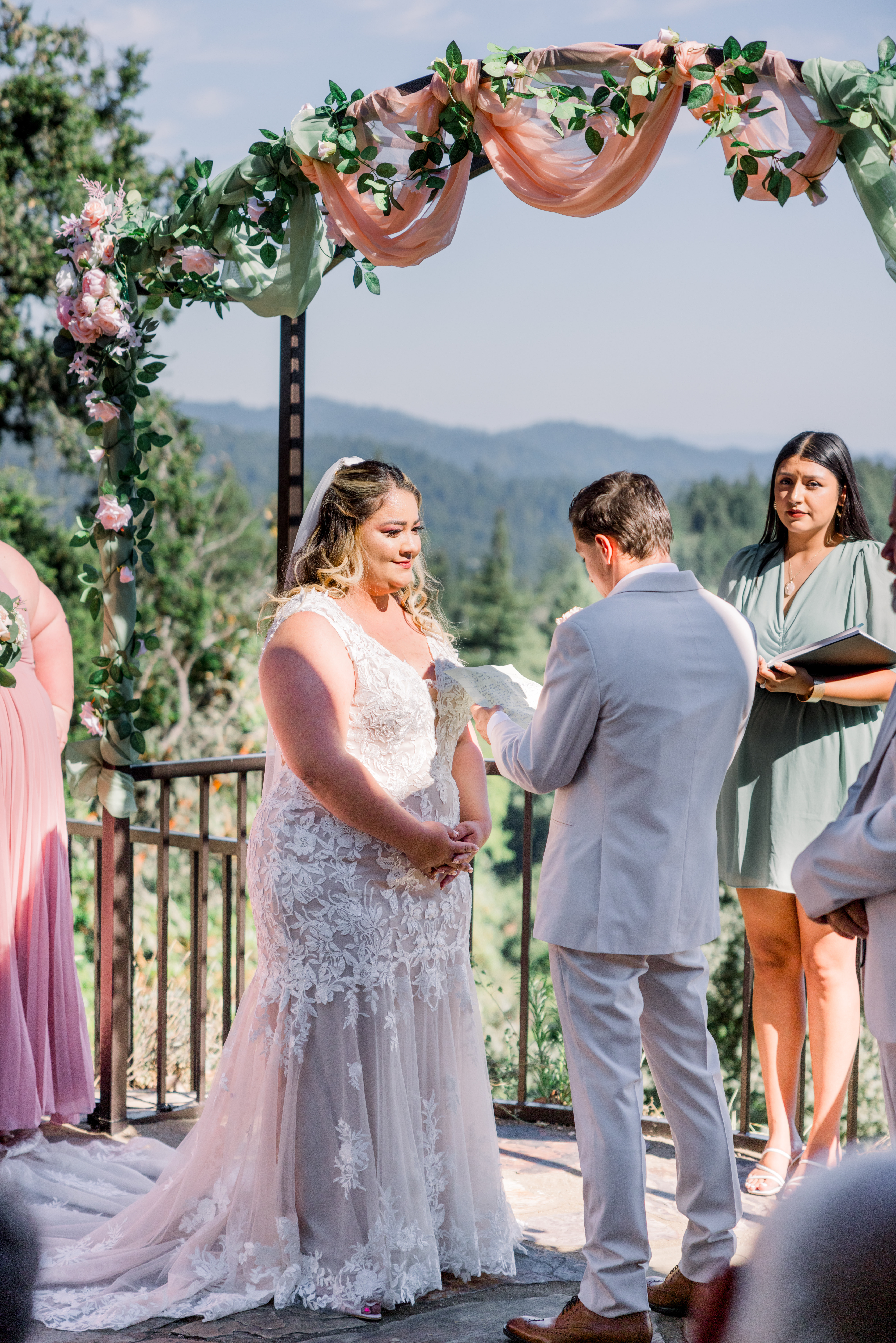Bride exchanging vows under floral arch at Living Well Event Center