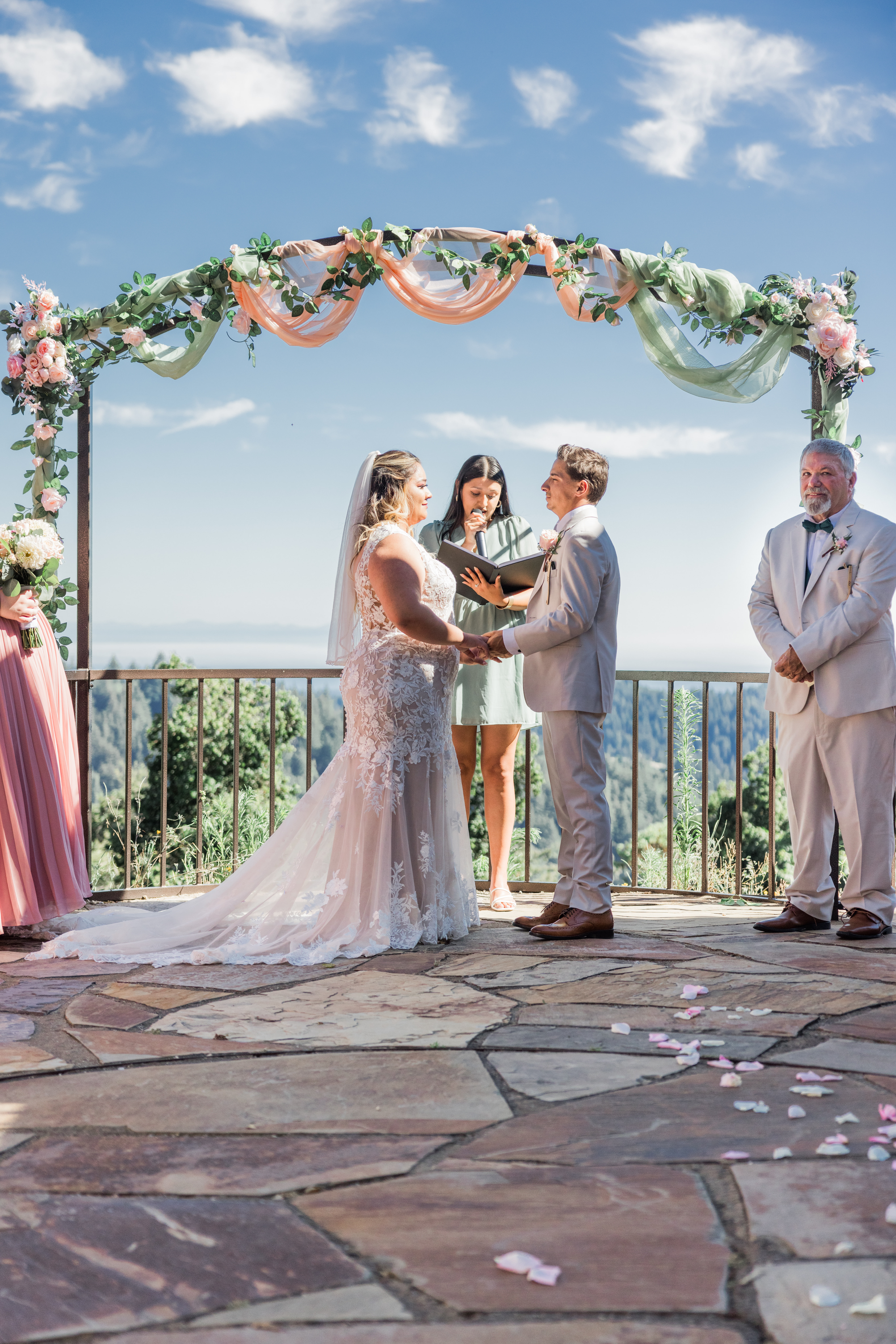 Wedding ceremony under floral arch at Living Well Event Center Los Gatos