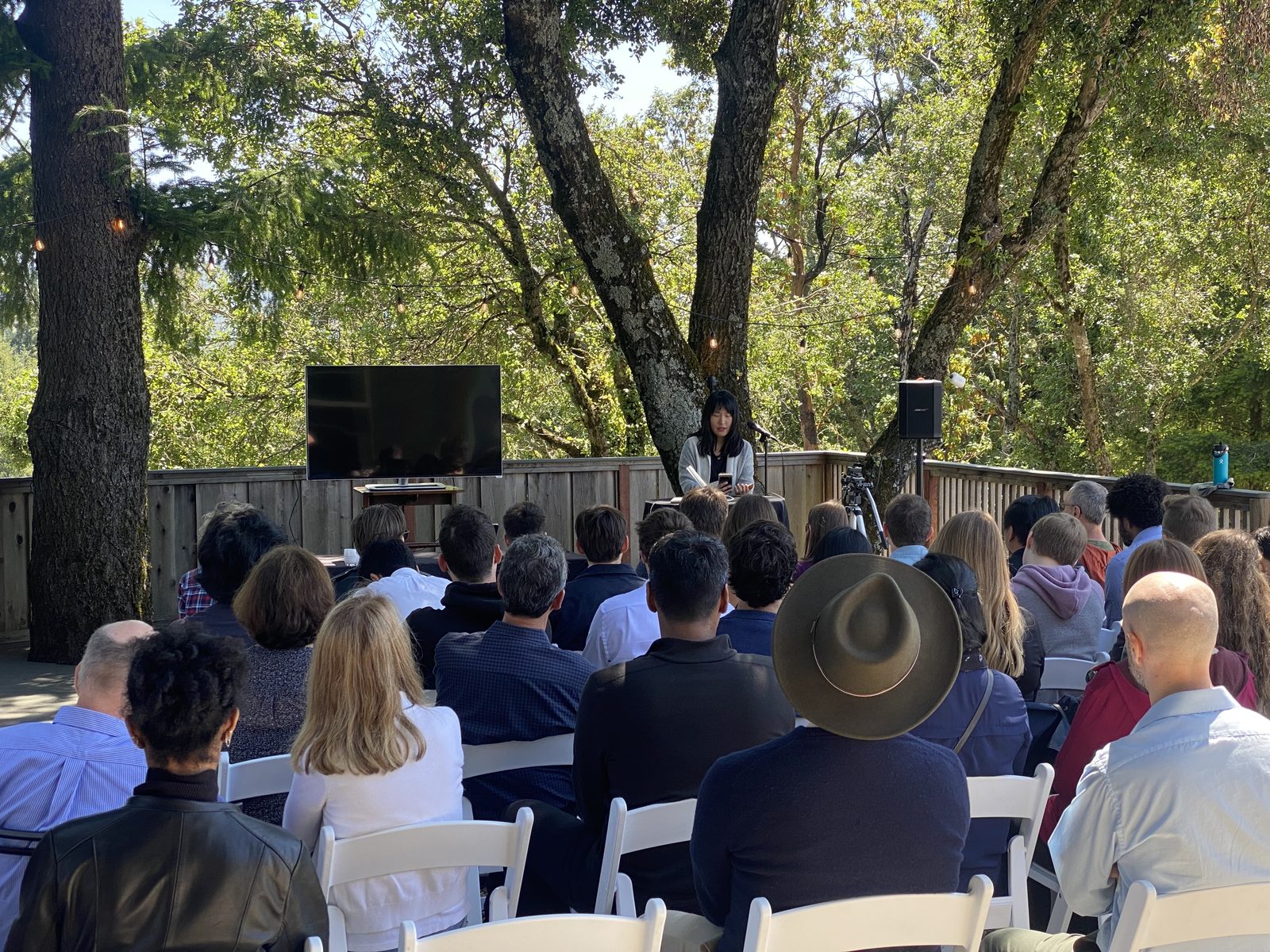 Speaker presenting on the outdoor deck during a seminar at Living Well Event Center
