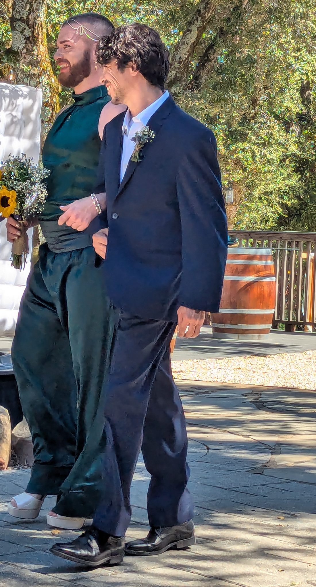 Two grooms walking arm in arm at their wedding at Living Well Event Center in Los Gatos